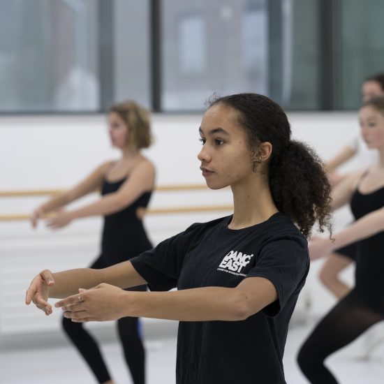 Student in ballet class with arms in a held position